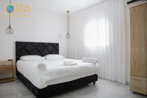 a bedroom with a large bed with white sheets at צופית דירות אירוח 2 דירות, האחת חדר שינה וסלון והשניה 2 חדרי שינה וסלון in Eilat