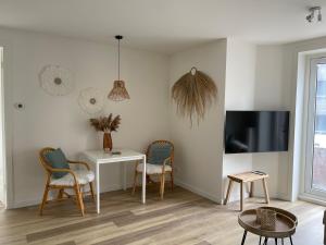 ein Wohnzimmer mit einem Tisch und Stühlen sowie einem TV in der Unterkunft Pure Apartment in Zandvoort