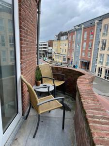 eine Terrasse mit 2 Stühlen und einem Tisch auf dem Balkon in der Unterkunft Pure Apartment in Zandvoort