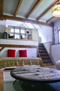 a room with a bed with red pillows and a table at grande Cahute in Soultzmatt