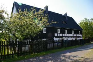 a black and white house with a fence at Roubenka Ruzova in Růžová