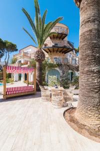 a resort with a palm tree and a table and chairs at Villa Piccola by Cassai in Colònia de Sant Jordi