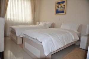 a bedroom with two beds with white blankets and pillows at Widder Rooms in Osijek