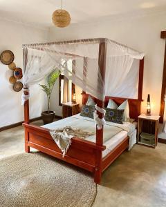 1 dormitorio con cama con dosel y alfombra en Utamaduni House B&B, en Arusha