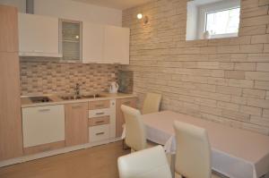 a kitchen with a table and chairs and a sink at Widder Rooms in Osijek