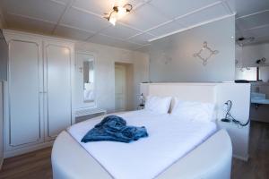 białe łóżko z niebieskim kocem w obiekcie Villa Ciardi Wellness Hotel & Ristorante w mieście Roana