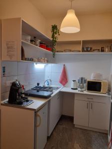 a kitchen with white cabinets and a counter top at Bella Badacsony Apartmanház in Badacsonytomaj