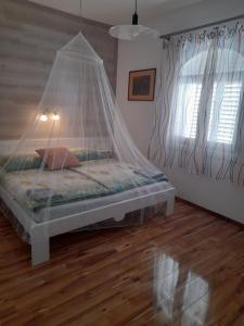 a bed with a net over it in a room at Bella Badacsony Apartmanház in Badacsonytomaj
