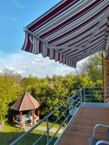 a deck with an umbrella and a gazebo at Bella Badacsony Apartmanház in Badacsonytomaj
