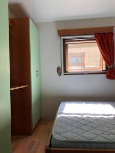 a small bedroom with a bed and a window at Buona Mobile Homes in Lido di Spina