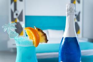una bottiglia blu e un bicchiere con una fetta arancione di Sunsan Hotel a Çanakkale