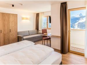 サン・ヴィジリオ・ディ・マレッベにあるGarni B&B Chi Vaiのベッド2台とソファが備わるホテルルームです。