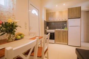 a kitchen with a table and a white refrigerator at Anna Studios in Agios Georgios