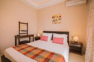 a bedroom with a bed with pink pillows at Anna Studios in Agios Georgios