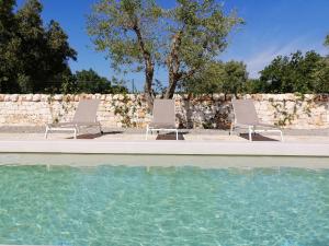 two chairs sitting next to a swimming pool at Intornoalnoce in Cisternino