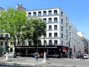 un gran edificio blanco en una calle de la ciudad con gente caminando en Hôtel Elysées Paris, en París