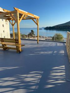 a wooden bench on a boardwalk near the water at Overwave Apartment in Kavála