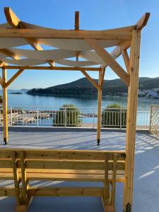 a wooden pergola with a view of the water at Overwave Apartment in Kavála