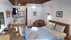 a bedroom with a bed and a desk and a kitchen at Egeon Studios in Neos Marmaras +69 photos