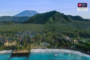 an aerial view of a resort with a mountain in the background at Candi Beach Resort & Spa in Candidasa