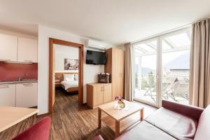 ein Wohnzimmer mit einem Sofa und einem großen Fenster in der Unterkunft AMELIA apartments in Dorf Tirol