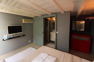 a bedroom with a bed and a flat screen tv at ZEVKLİLER ALAÇATI hotel in Alacati