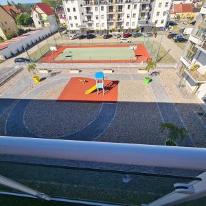uitzicht op een speeltuin met een basketbalveld bij Apartament nad klifem w Dziwnówku in Dziwnówek