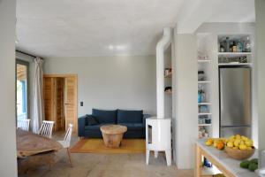 ein Wohnzimmer mit einem blauen Sofa und einem Tisch in der Unterkunft Vanua house in Galatás