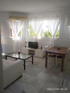 salon ze stołem i kanapą w obiekcie Apartamentos Sanlúcar Beach 2 y 3 w mieście Sanlúcar de Barrameda