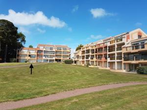 a grassy field in front of some apartment buildings at Appartement Face a la Mer in Pornic