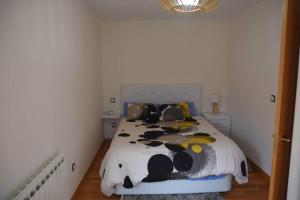 a bedroom with a bed with a cow blanket at Dúplex con soleada terraza! in Renedo de Piélagos
