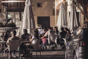 eine Gruppe von Personen, die in einem Restaurant im Freien auf Stühlen sitzen in der Unterkunft Hostal LA DEHESA DEL VALLE PEDROCHES in Alcaracejos