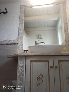 een badkamer met een wastafel en een spiegel bij Bello Bello Rooms in Santa Teresa Gallura