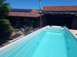 a blue swimming pool in front of a house at la cabane vensac ocean montalivet in Vensac