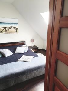 a bedroom with a bed with blue sheets and white pillows at Apartament Łeba in Żarnowska