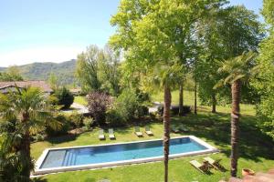 ein Swimmingpool in einem Garten mit Palmen in der Unterkunft L'Auberge Basque-Relais & Châteaux in Saint-Pée-sur-Nivelle