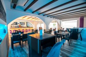 een restaurant met tafels en stoelen in een kamer bij Hotel Tarba in San Antonio