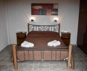 a bedroom with a bed with two white towels on it at PANORAMA VILLA'S in Lévktron
