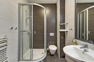 een badkamer met een douche, een wastafel en een toilet bij Abak in Gdańsk
