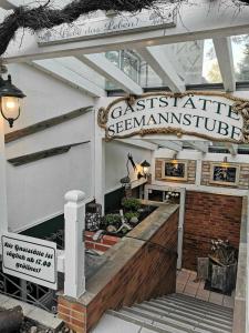 a restaurant with a sign on the front of a building at Pension Am Strand in Juliusruh