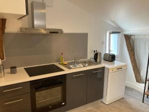a kitchen with a sink and a stove top oven at les toits d'Agen in Agen +8 photos