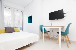 a bedroom with a bed and a desk and two chairs at Blue River - Pulaskiego B - private Apartment in Wrocław
