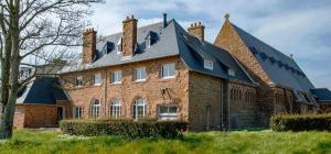 a large brick house with a gambrel roof at Le Presbytère du Talbert in Pleubian