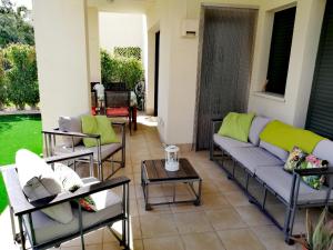 eine Terrasse mit Sofas und einem Tisch in der Unterkunft gelijkvloers appartement Corvera Golf & Country Club in Corvera