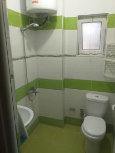 a bathroom with a toilet and a tub and a window at Villa Selmani in Ksamil