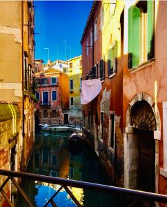 un canal entre dos edificios con un barco en el agua en Mascherone Apartment, en Venecia