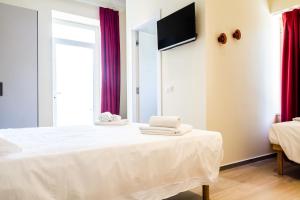 1 dormitorio con 1 cama con ordenador portátil en Le Bifore, en Gaeta
