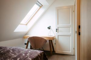 1 dormitorio con escritorio, ventana y cama en Wiedemanni 13/1 apartments en Haapsalu