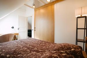 1 dormitorio con 1 cama con pared de madera en Wiedemanni 13/1 apartments en Haapsalu