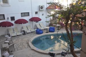 a hotel with a pool and chairs and umbrellas at Dalyando Apart in Dalyan